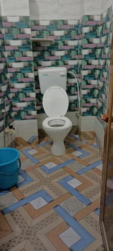 a bathroom with a toilet in a room with books at Mayapur Yatri Nivas in mayapur