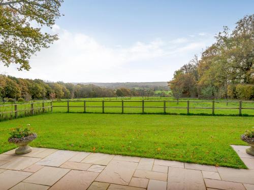 a garden with a fence and a grass field at Windover Barn in Slinfold