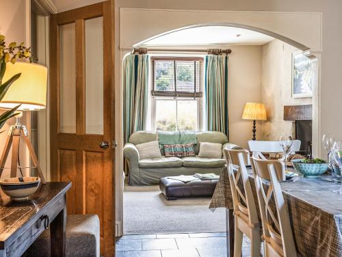 a kitchen with a table and a living room at Goat Street Cottage in St. Davids