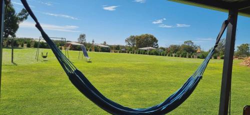 a hammock in a park with a field of grass at One Life Live It Farm stay Retro VanStay in Dareton
