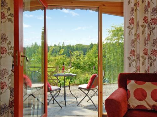 een afgeschermde veranda met een tafel en stoelen bij Ria's Cottage in Landshipping