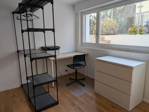 a room with a desk and a chair next to a window at Renovierte Wohnung in 8903 Birmensdorf in Birmensdorf