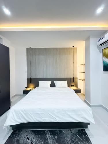 a bedroom with a large white bed with white sheets at Dateheight Apt in Lekki