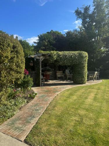 a garden with a pergola and a bench at Riverslea on Farndon in Clive