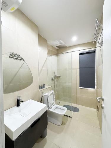 a bathroom with a toilet and a sink and a shower at Dateheight Apt in Lekki
