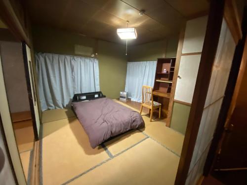 a small room with a bed and a chair at 九州 福岡 貸切 プライベートハウス 