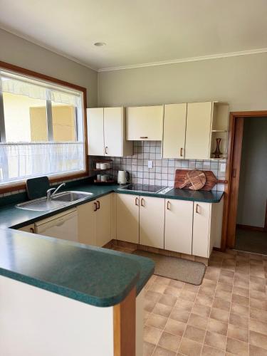 a kitchen with white cabinets and a counter top at Riverslea on Farndon in Clive