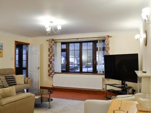 AbergynolwynにあるHoot Houseの大きな窓とテレビのあるリビングルーム