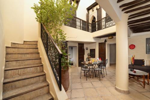 eine Treppe in einem Haus mit einem Tisch und Stühlen in der Unterkunft Riad Privé Dar El Khamsa-Petit Dej inclus in Marrakesch