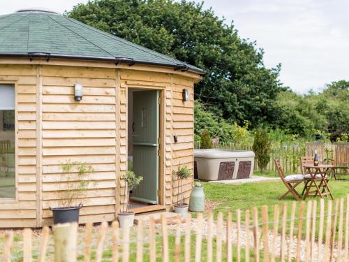 a wooden cabin in a garden with a fence at Olive in Wootton Bridge