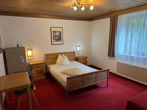 a bedroom with a bed and a table and a window at Schönmoosalm - Four-Bedroom Standard Apartment in Krimml