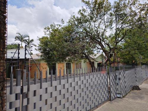 een wit hek voor een huis bij Laroza guest house in Rustenburg