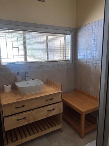 a bathroom with a sink and a counter with a tub at Laroza guest house in Rustenburg