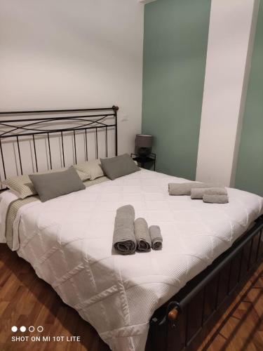 a bed with two towels and two slippers on it at amaRE in Reggio Emilia