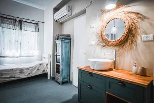 a bathroom with a sink and a mirror and a bed at וילה בקיבוץ דפנה - אירוח וטיולים בלב טבע פראי in Metsudat Menahem Ussishkin Alef
