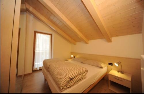um quarto com duas camas e um teto de madeira em Appartamenti Vegaia em Peio