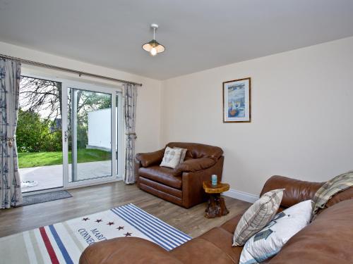 a living room with a couch and a chair at Orestone Garden Apartment in Dawlish
