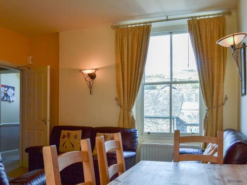 a living room with a table and chairs and a window at Fell View in Ambleside