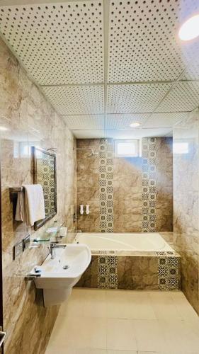 a bathroom with a sink and a bath tub at Kabul Taj Hotel in Kabul