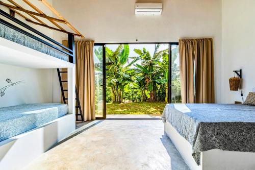 a bedroom with two beds and a large window at Private rainforest villa up to 8 guests w jacuzzi near Rio Celeste in Upala