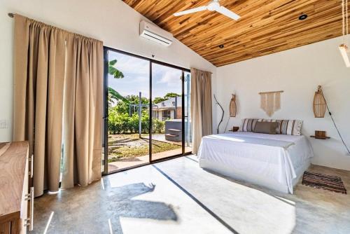 a bedroom with a bed and a large window at Private rainforest villa up to 8 guests w jacuzzi near Rio Celeste in Upala