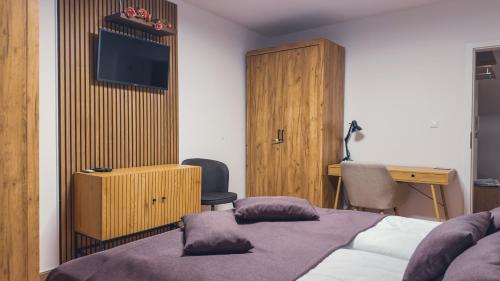 a hotel room with a bed and a desk and a television at Apartmán Astana in Levoča