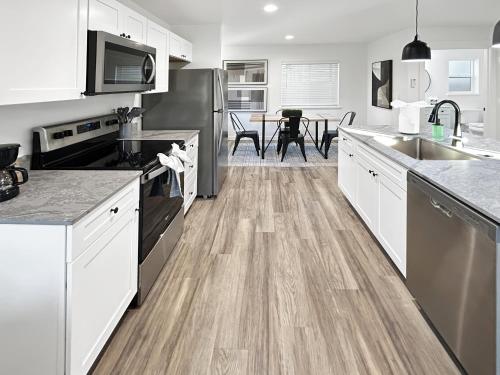 uma cozinha com armários brancos e piso de madeira em The Maverick Haus townhouse em Grand Junction