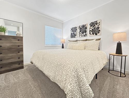 um quarto branco com uma cama e uma cómoda em The Maverick Haus townhouse em Grand Junction