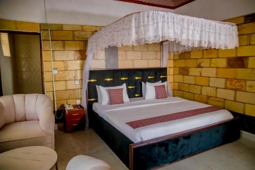 ein Schlafzimmer mit einem Bett und einem Stuhl in der Unterkunft Kigufi Hill Hotel & Agape Resort in Gisenyi