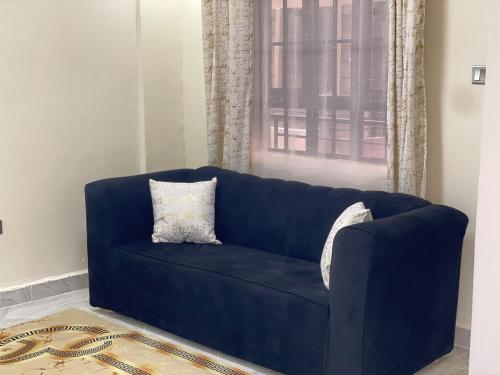 a blue couch in a living room with a window at Calm getaway in Rongai in Ongata Rongai 
