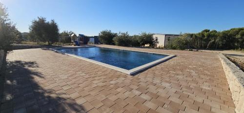 a swimming pool in the middle of a brick patio at Maui, Kamp Heron, Drage, Croatia in Drage