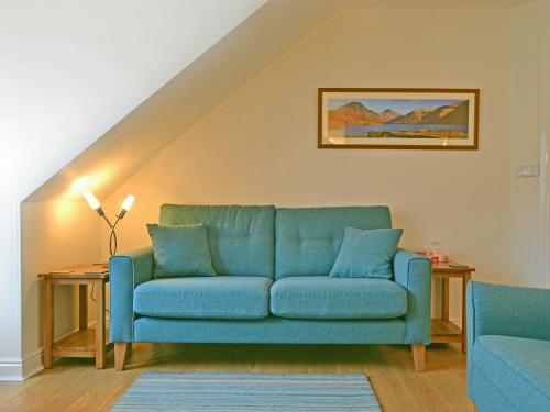 a blue couch sitting in a living room at Herdwick Heights in Keswick