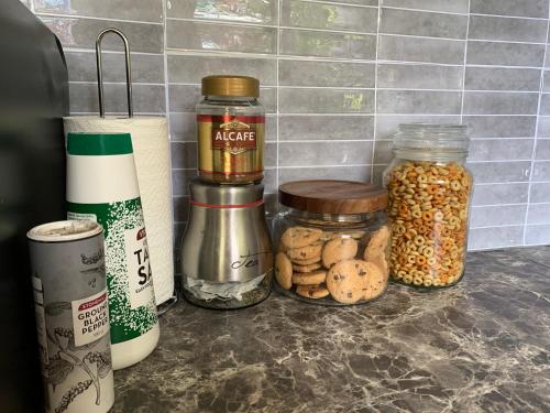 a kitchen counter with jars of food on it at Stylish Chic King Bedroom in Mount Colah
