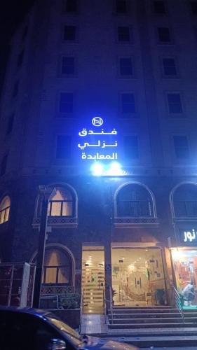a sign on the side of a building at night at فندق نزلي المعابدة in Miná