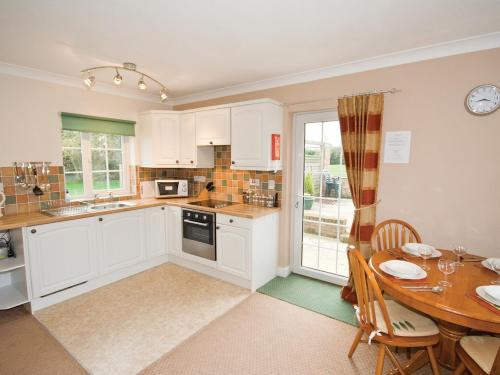 a kitchen with a table and a dining room at Curlew Cottage - E3752 in Leverton