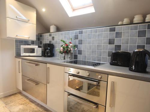 a kitchen with blue tiles on the wall at The Stable - Hw7461 in Henrys Moat