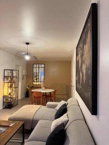 een woonkamer met een bank en een tafel bij Le Monde des Dunes - T3 - Parking privé in Angers