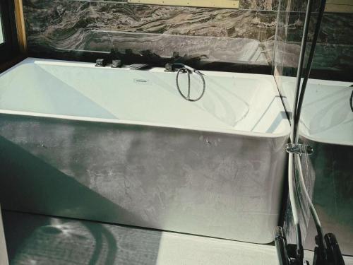 a bathtub in a room with a glass at 苗場サンバレーホテル in Minami Uonuma