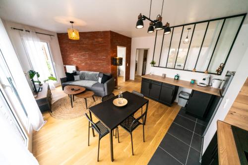 a living room with a table and chairs and a couch at T3 BROOKLYN - Luminous - Central - Wifi - Parking in Nanterre