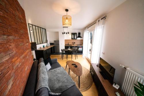 a living room with a couch and a table at T3 BROOKLYN - Luminous - Central - Wifi - Parking in Nanterre
