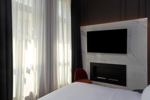 a bedroom with a bed and a tv and a window at Athens Icon Collection in Athens