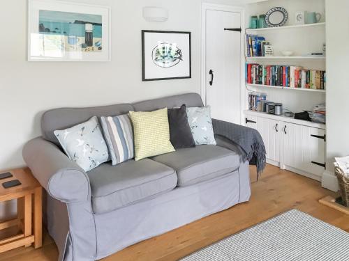 a living room with a gray couch with pillows at Mainbrace in Port Isaac