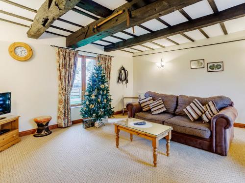 a living room with a couch and a christmas tree at Timbers Barn - E3863 in Runcton Holme