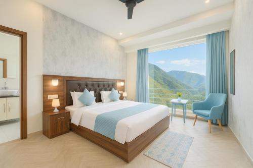 a bedroom with a bed and a large window at Doon Nature Valley Resort, Mussoorie in Mussoorie