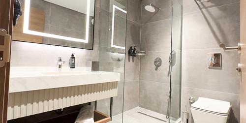 a bathroom with a shower and a sink and a toilet at Paşapark Selçuklu Hotel in Konya