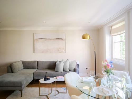 a living room with a couch and a table at Upscale Apartment in a Prestigious Area in London