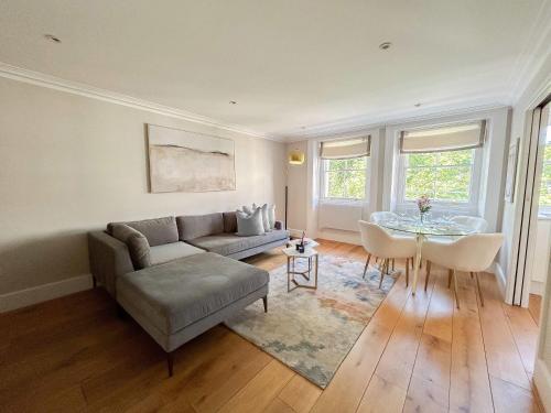 a living room with a couch and a table at Upscale Apartment in a Prestigious Area in London