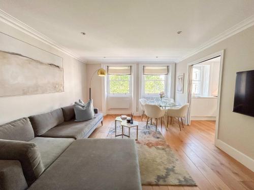 a living room with a couch and a table at Upscale Apartment in a Prestigious Area in London