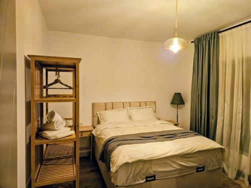 a bedroom with a bed and a shelf with a mirror at RuMa Home Zarnesti in Zărneşti