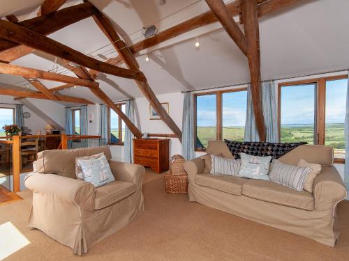 een woonkamer met 2 banken en ramen bij Lighthouse Watch in Saint Nicholas